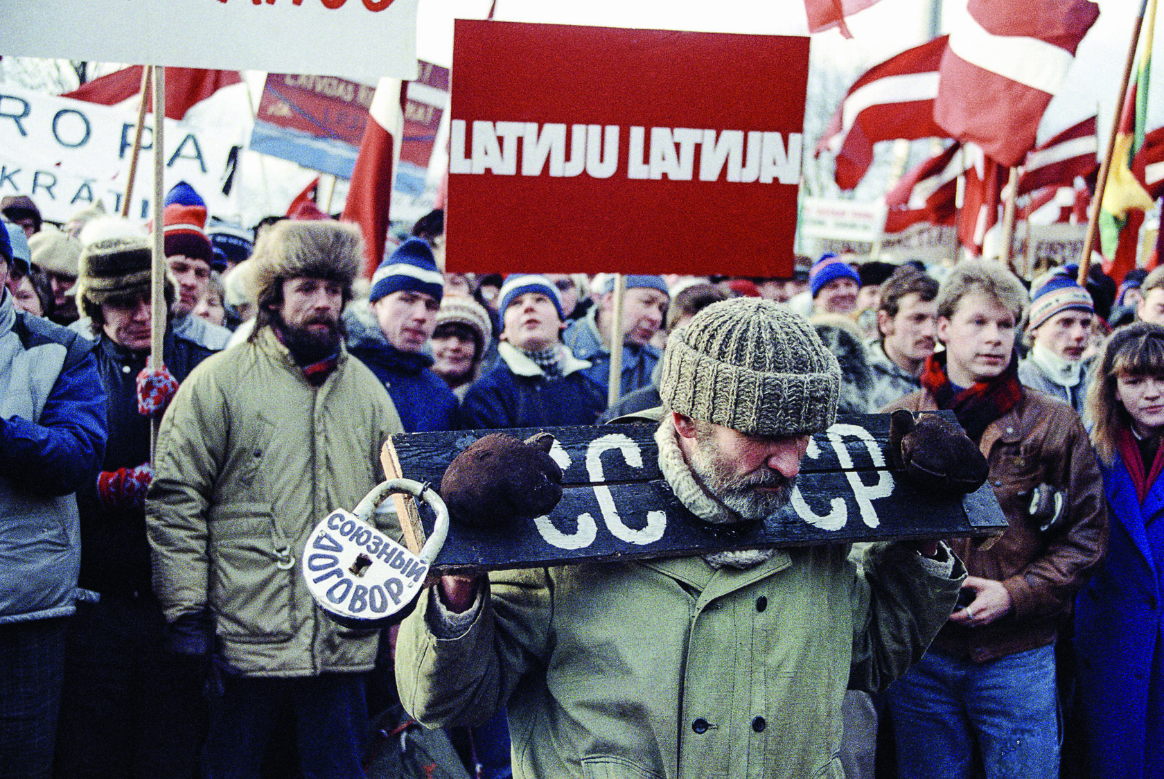 Демонстрант в кандалах на митинге за независимость Латвии, символ замка на свободе