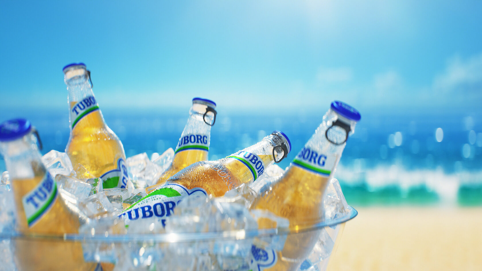 Tuborg LITE bottles in an ice bucket beside the sea