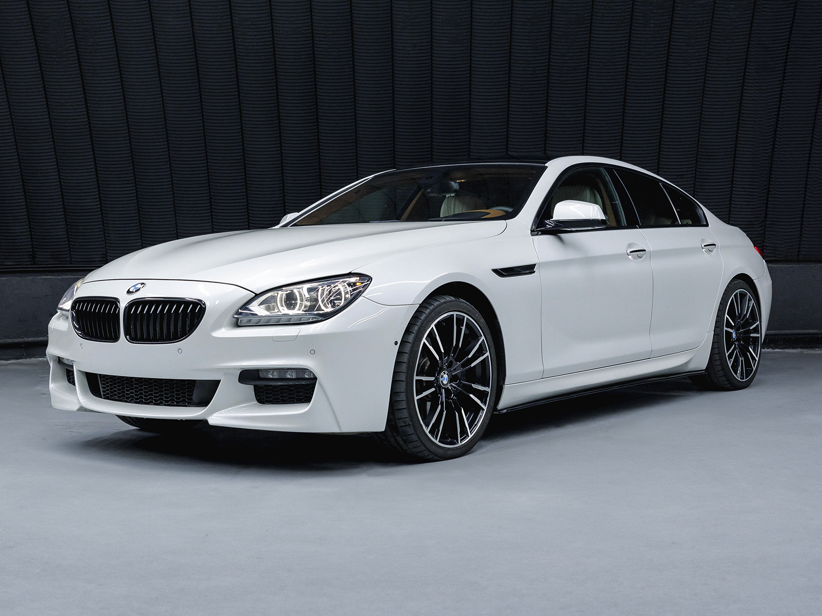 На данном изображении представлен автомобиль BMW 640d Gran Coupe, воплощение элегантности и динамики. Этот четырехдверный купе отличается изысканным дизайном и мощным двигателем, обеспечивая высокий уровень комфорта и производительности. Кузов автомобиля выполнен в элегантных оттенках, подчеркивая его роскошный и современный облик. Динамичные линии и утонченные детали создают гармоничный баланс между стилем и функциональностью, а характерные черты Gran Coupe добавляют уникальности. Легкосплавные диски колес и фирменные элементы дизайна BMW дополняют общий внешний вид, а логотип на передней решетке говорит о премиальном качестве марки. Это изображение передает не только эстетику автомобиля, но и обещание утонченности и удовольствия от вождения.