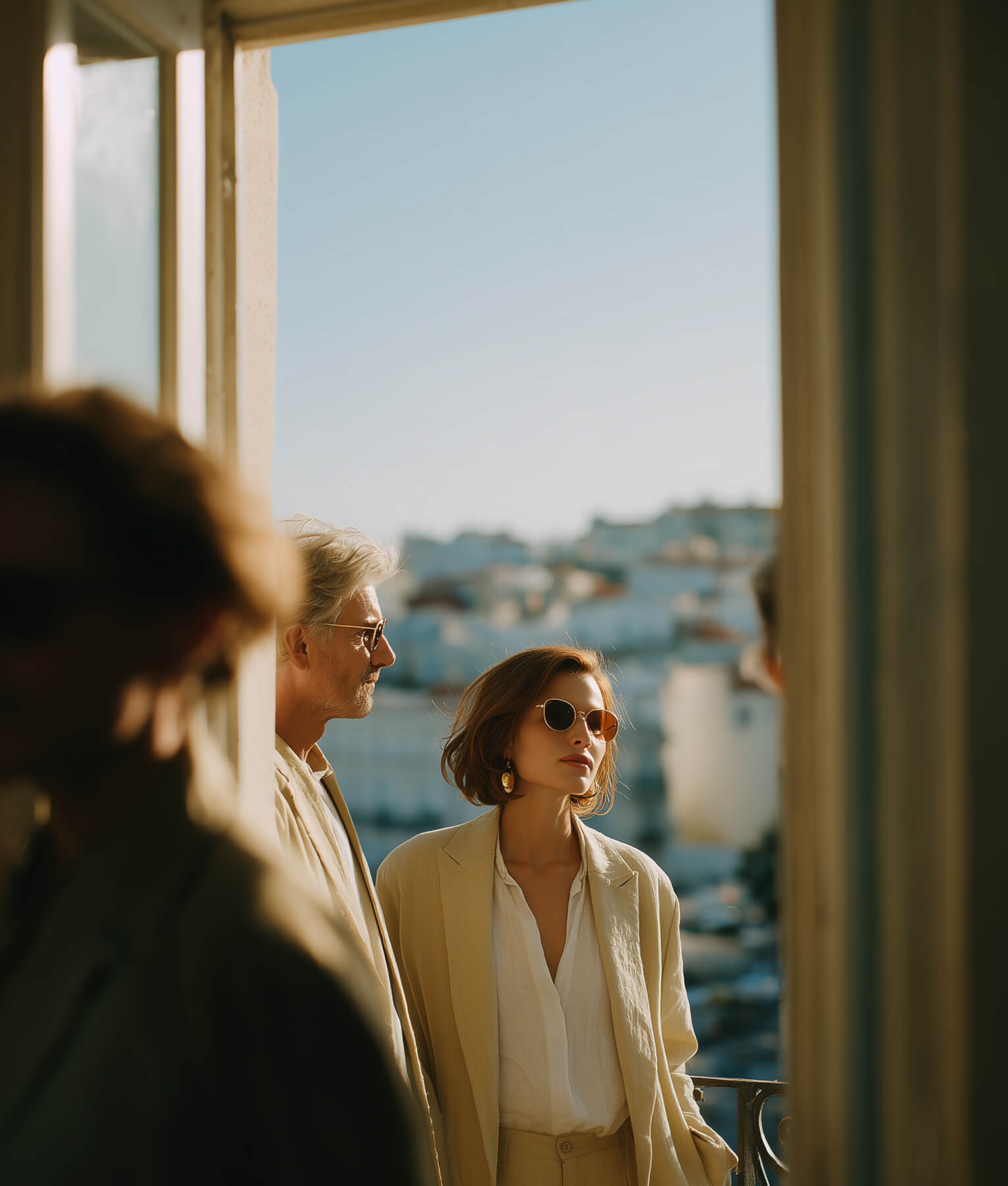 Two women viewing coastal Mediterranean seascape through large window of Liguria property, and below, residential house facade with green shutters, entrance door, and garden landscaping for property sales and investment services.