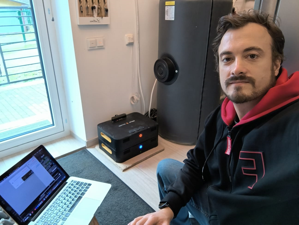 A person sitting on the floor with a computer
Description automatically generated