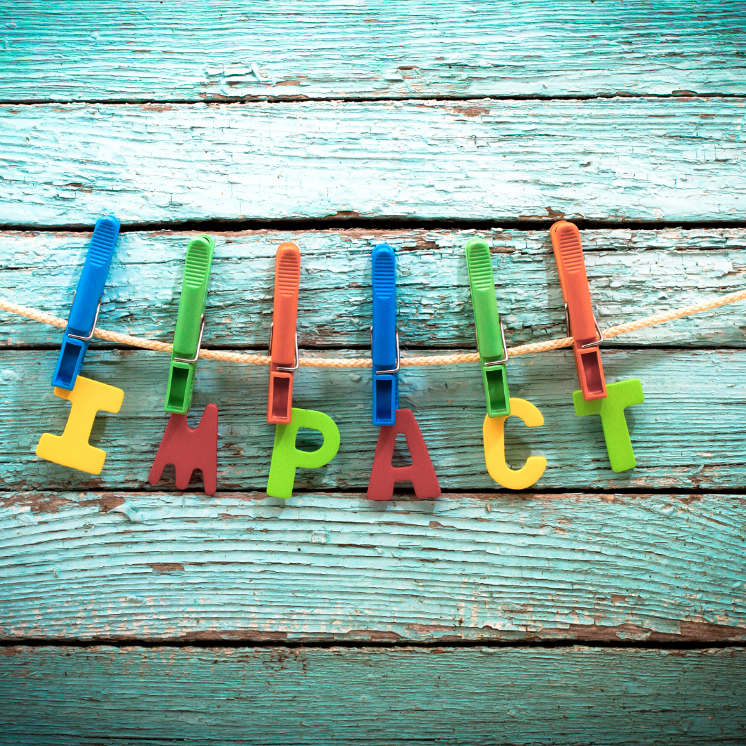 Close pins holding the words Impact