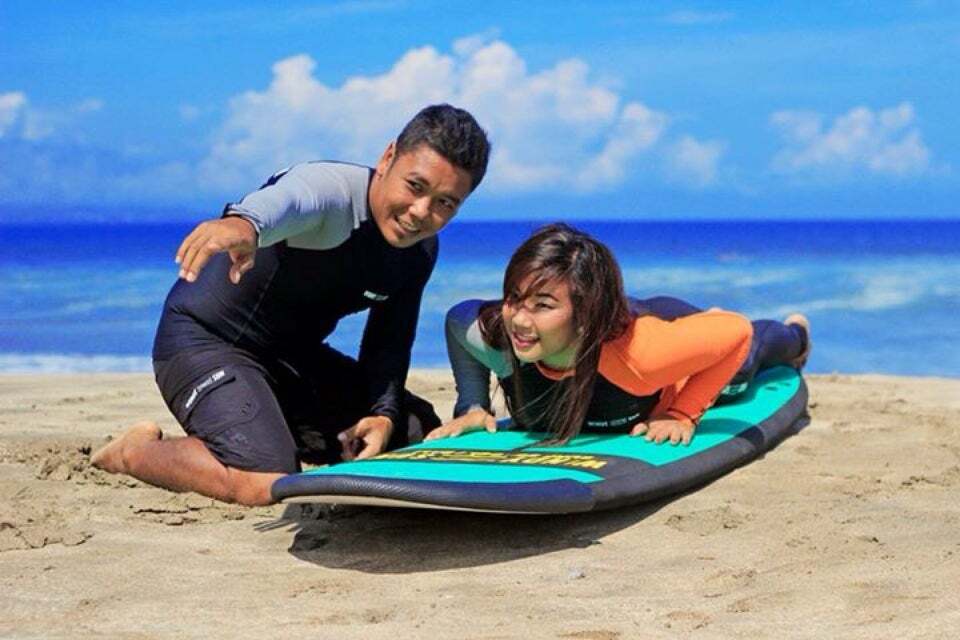 surf coach teaching woman