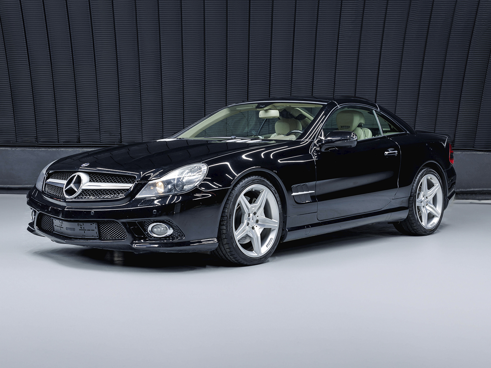 На данном изображении представлен автомобиль Mercedes-Benz SL 550, воплощение роскоши и стиля. Этот роскошный кабриолет сочетает в себе элегантный дизайн и передовые технологии, предоставляя увлекательный опыт вождения. Кузов автомобиля выполнен в классическом черном цвете, придавая ему элегантность и статус. Динамичные линии и характерные черты дизайна Mercedes-Benz подчеркивают статус и спортивный характер этой модели, а черный цвет делает SL 550 выразительным и внушительным. Логотип Mercedes-Benz на передней и задней части автомобиля говорит о высоком качестве и статусе марки. Это изображение передает не только внешний вид автомобиля, но и обещание роскоши и элегантности, характерных для Mercedes-Benz SL 550.